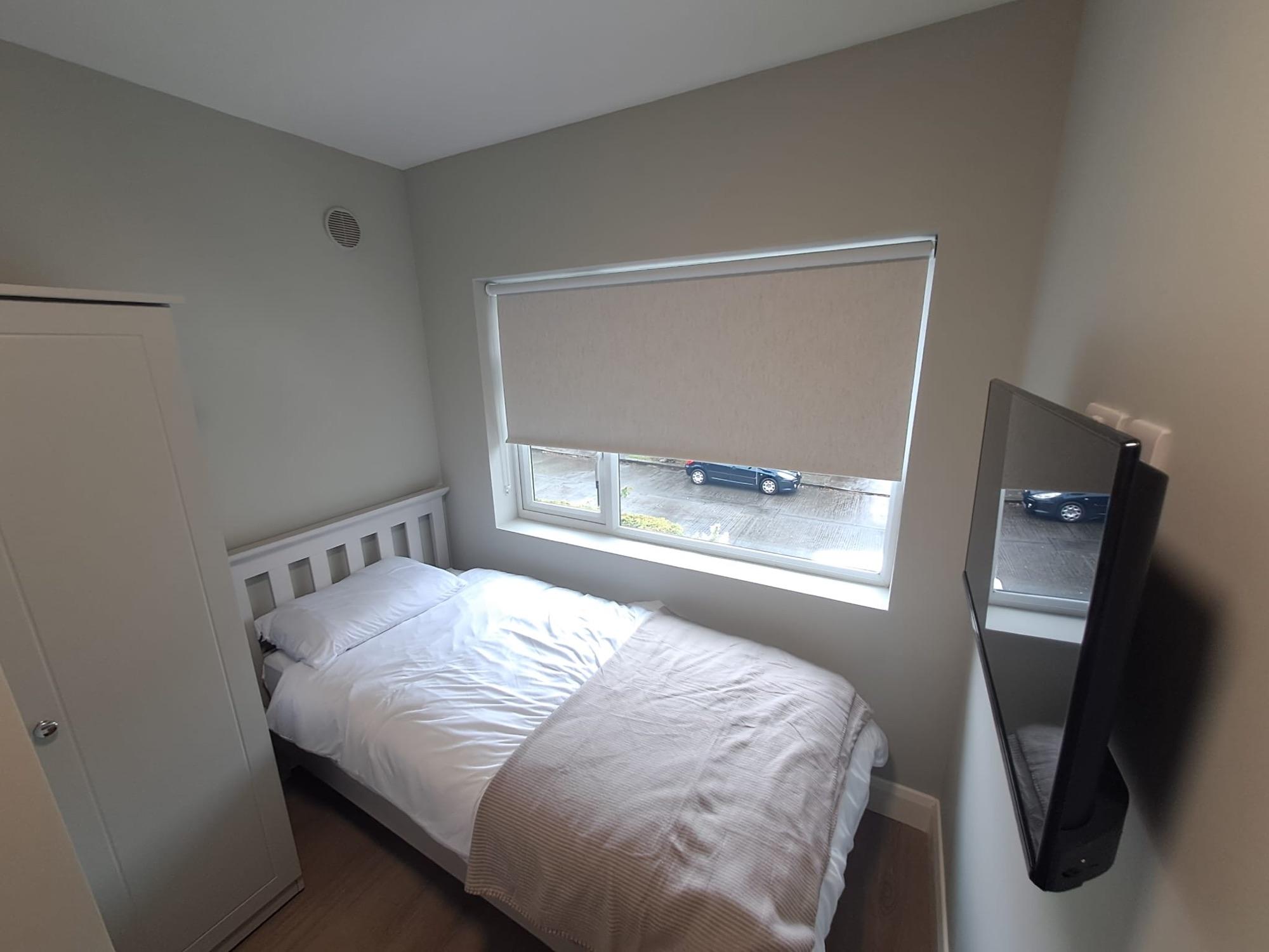 Single bedroom with a wall-mounted TV