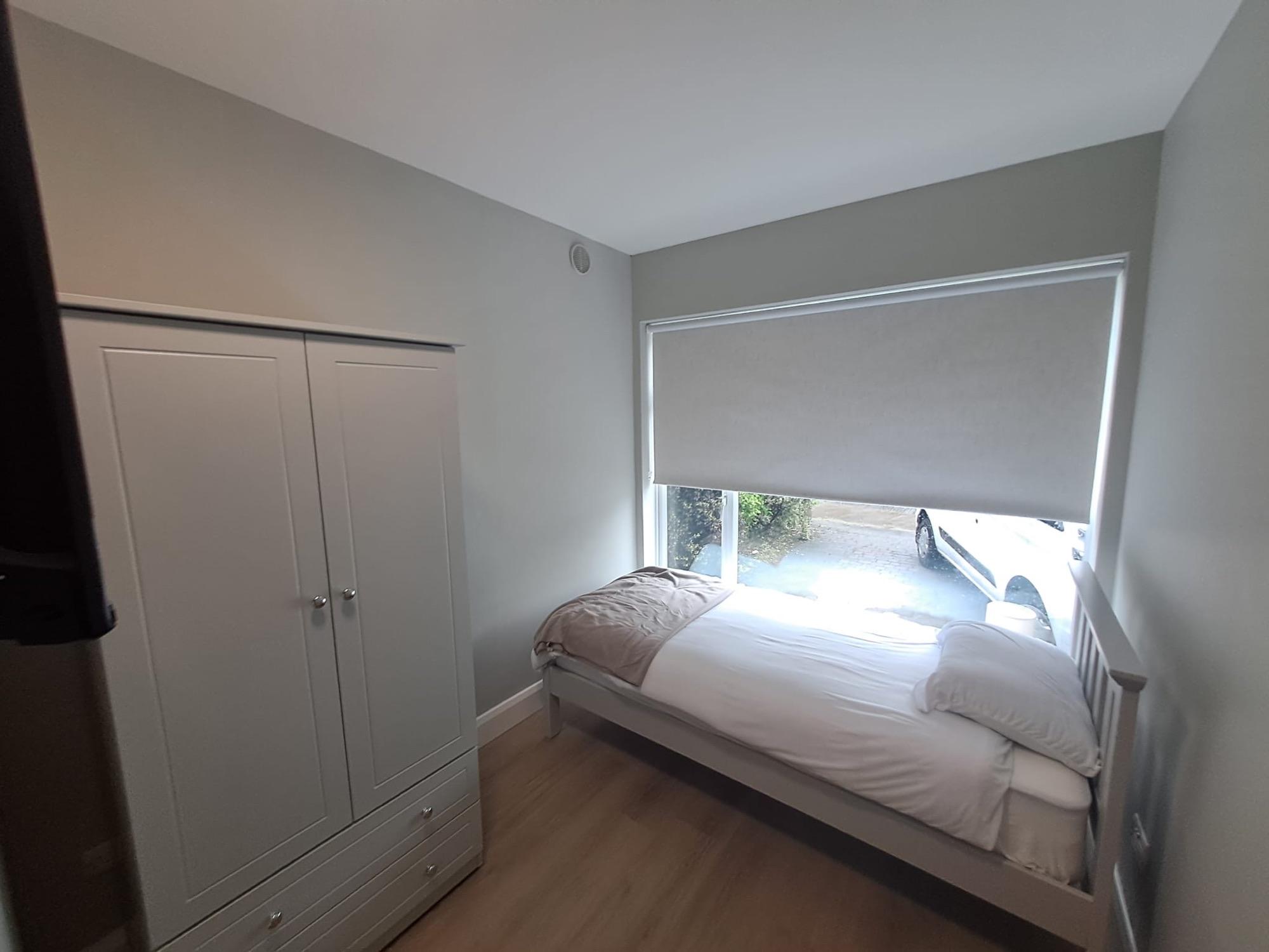 Bedroom with a white wardrobe and a double bed