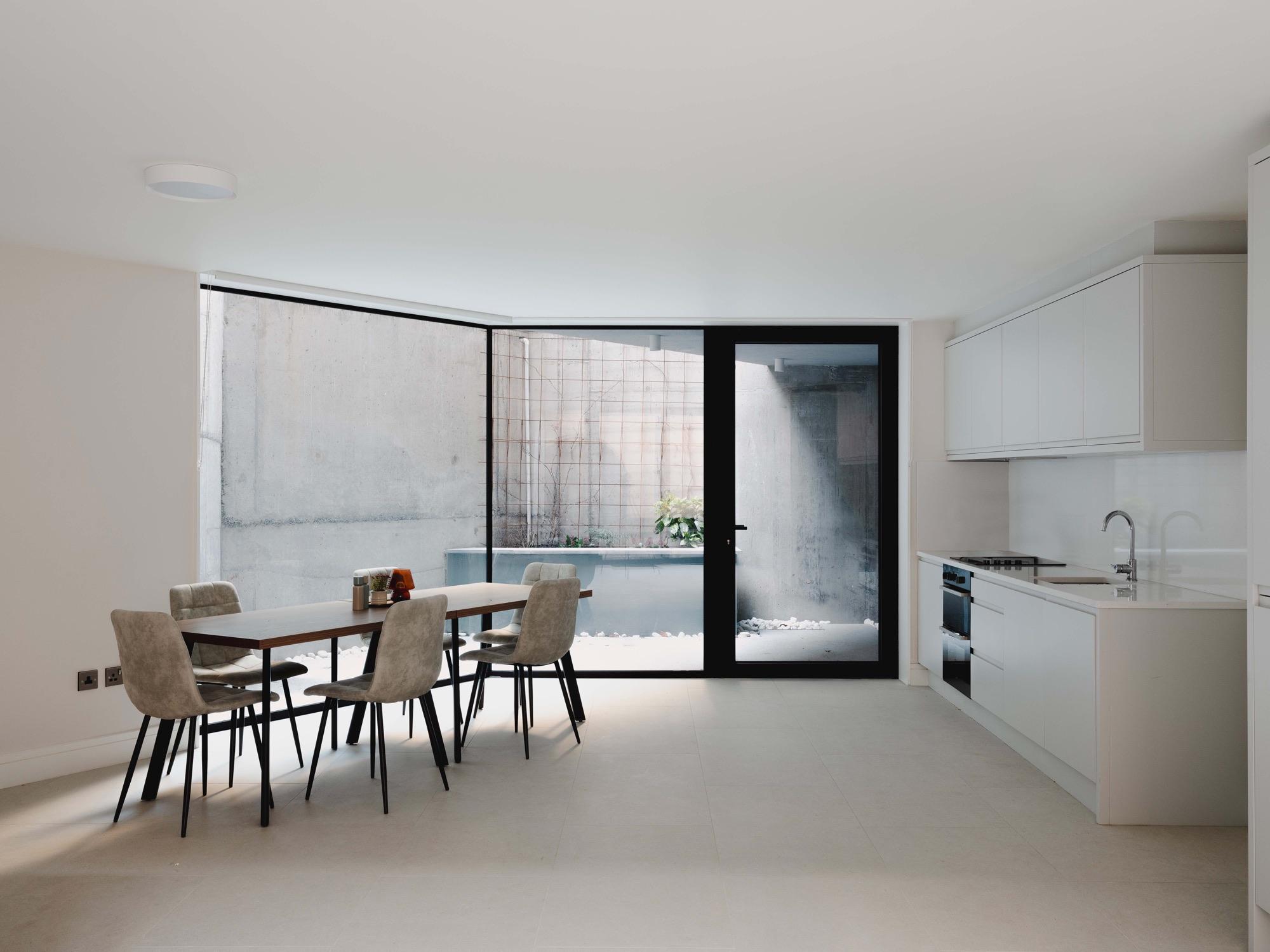 Bright open-plan kitchen and dining space with floor-to-ceiling glazing