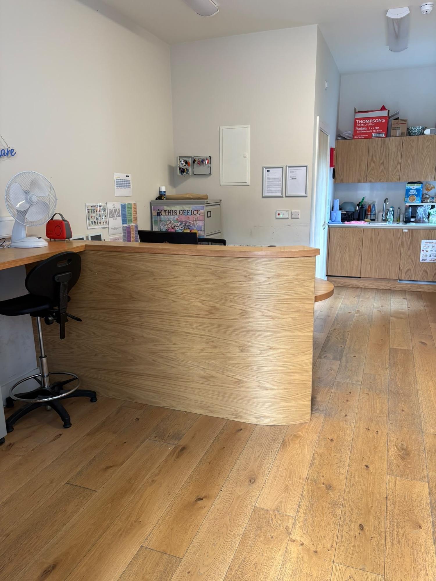 Reception and office space with a curved wooden desk